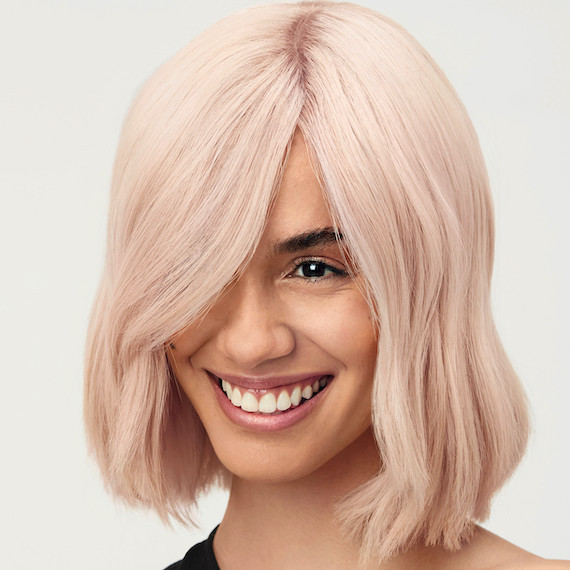 Model with a chin-length, long bob haircut in a strawberry vanilla blonde hair.