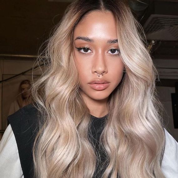 Model with long, golden vanilla blonde hair styled in tousled waves.