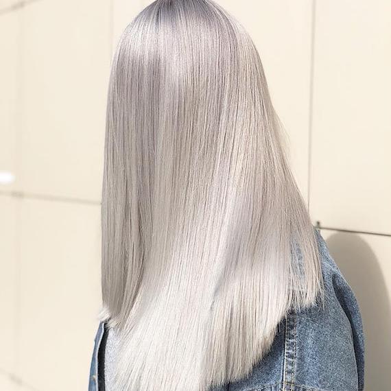 Foto, das den Hinterkopf einer Frau mit super-glatten, langen, eisblonden Haaren zeigt. Kreiert mit Wella Professionals.