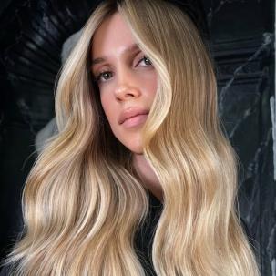 Model with long, glossy, wavy, golden blonde hair.