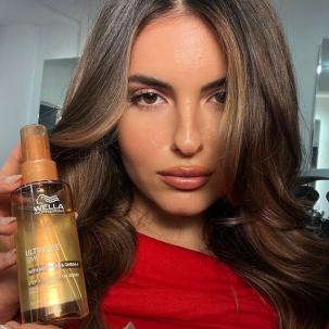 Model with long, brunette hair styled in glossy waves.