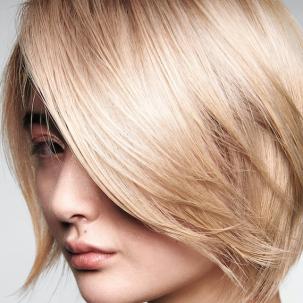 Model with short, chin-length bob in a glassy butter blonde shade.