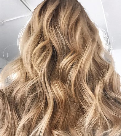 Photo of the back of a woman’s head with long, soft powdered blonde hair, created using Wella Professionals.