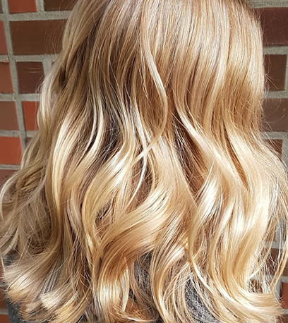 Side profile of woman with powdered blonde hair and pink highlights, created using Wella Professionals.
