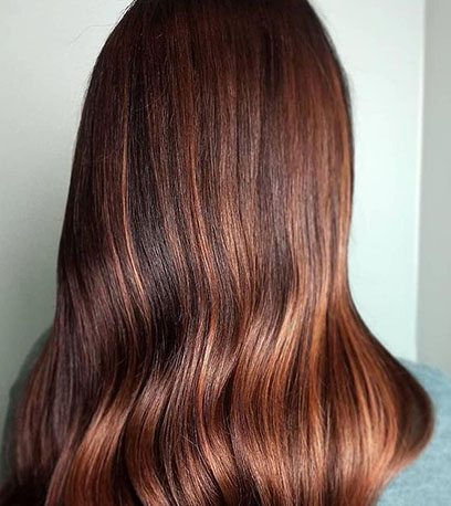 Back of woman’s head with shoulder-length copper brown hair, created using Wella Professionals
