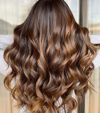 Back of woman’s head with long, wavy, mahogany brown hair, created using Wella Professionals
