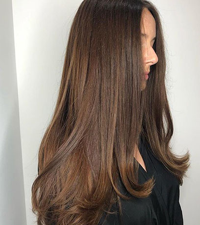 Alt tag: Woman with long, sleek brown hair, created using Wella Professionals