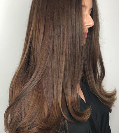 Side profile of a person with long, straight chocolate brown hair