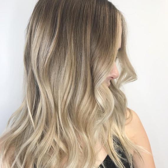 Model mit langem, dunkelblondem Haar und hellblonder Balayage, kreiert von Wella Professionals.