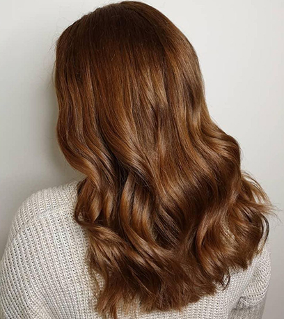 Back of woman’s head with long, wavy, vintage brown hair, created using Wella Professionals.