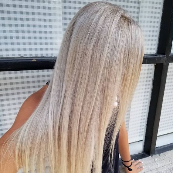 Woman with long straight ice blonde hair using Wella Professionals Color Touch
