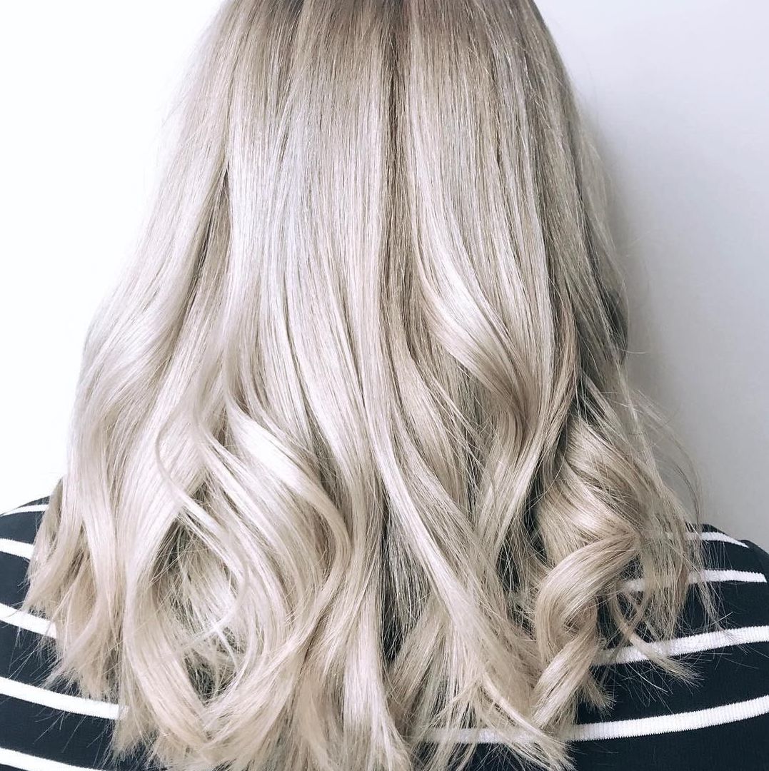 Woman with long wavy ice blonde hair using Koleston Perfect