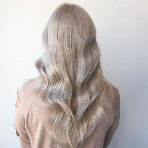 Woman with long wavy ice blonde hair using Blondor Powder