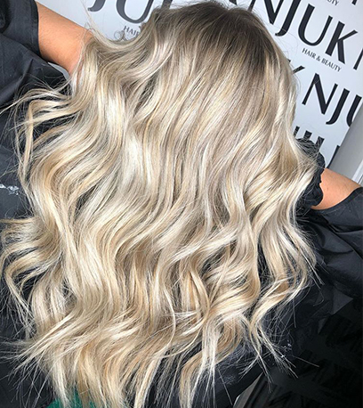 Back of womans head with curled soft blonde hair