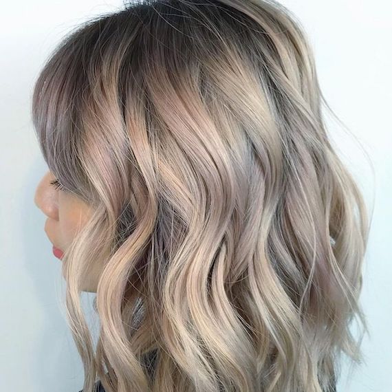 Model with wavy hair and hidden highlights, created using Wella Professionals.