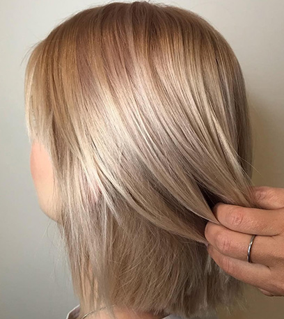 Model with straight hair and subtle pink highlights, created using Wella Professionals.