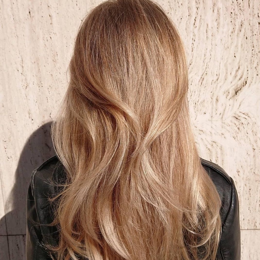 Model mit langen welligen Haaren in warmem Blond und Highlights, die mit Blondor Freelights und Color Touch kreiert wurden.