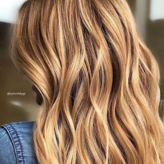 Model mit langen welligen Haaren in warmem Blond und Highlights, die mit Blondor Freelights und Color Touch kreiert wurden.
